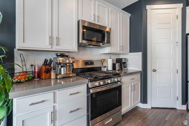 kitchen with white cabinetry, tasteful backsplash, stainless steel appliances, and dark wood-style floors