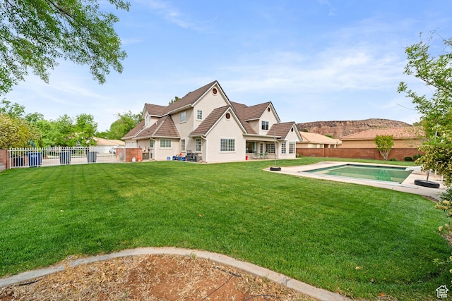 rear view of property featuring a fenced backyard and a yard