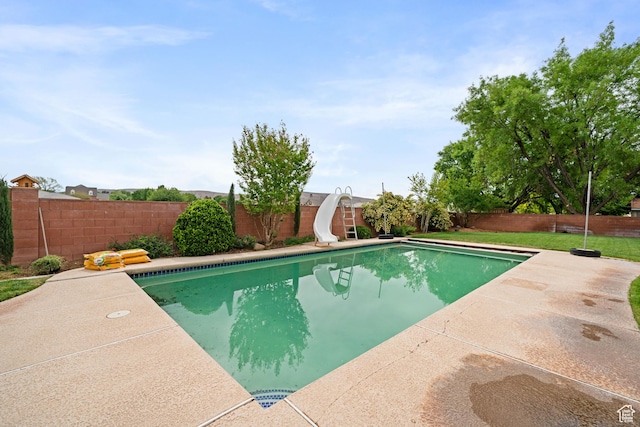 view of swimming pool with a fenced in pool, a patio area, a water slide, and a fenced backyard