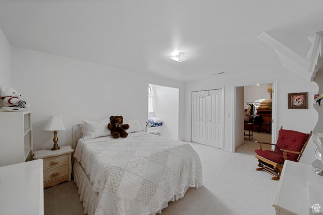 bedroom with light carpet and a closet