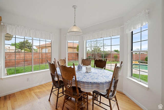 dining space with baseboards and light wood-type flooring