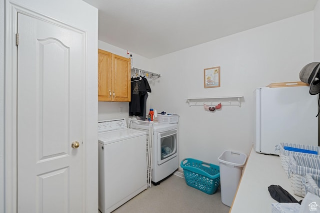 laundry area with light carpet, washer and dryer, and cabinet space