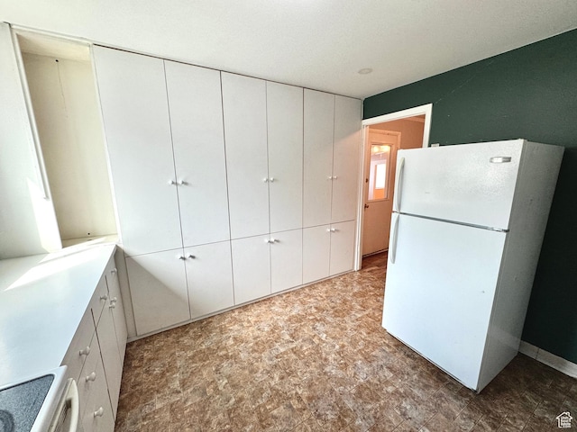 993 E 200 N, Provo, UT 84606 - kitchen with white cabinets, freestanding refrigerator, stove, stone finish flooring, and light countertops