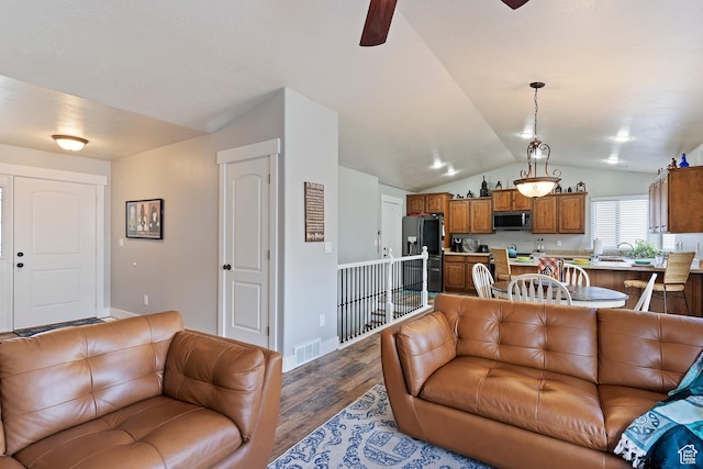 3295 S 1500 W, Perry, UT 84302 - living room featuring dark wood-style flooring, vaulted ceiling, baseboards, visible vents, and a ceiling fan