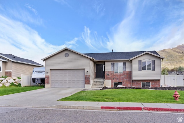 3295 S 1500 W, Perry, UT 84302 - view of front of house with concrete driveway, an attached garage, brick siding, and a front lawn