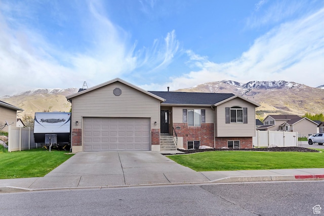 3295 S 1500 W, Perry, UT 84302 - ranch-style home featuring a front lawn, a mountain view, driveway, fence, and brick siding