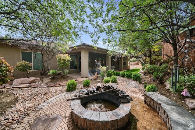 2356 S 1300 W, St George, UT 84770 - rear view of house with stucco siding, a patio area, and an outdoor fire pit