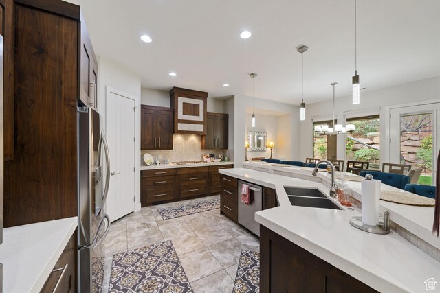 2356 S 1300 W, St George, UT 84770 - kitchen with stainless steel appliances, light countertops, dark brown cabinets, a sink, and decorative backsplash
