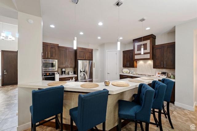2356 S 1300 W, St George, UT 84770 - kitchen featuring backsplash, light countertops, a kitchen bar, and stainless steel appliances