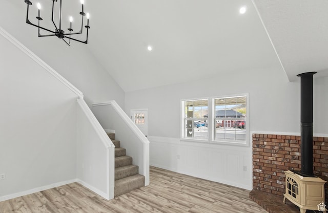 604 S Desert Willow Ln, Salina, UT 84654 - interior space featuring wood finished floors, wainscoting, a wood stove, a notable chandelier, and high vaulted ceiling