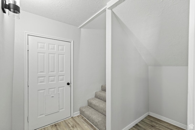 604 S Desert Willow Ln, Salina, UT 84654 - stairway with a textured ceiling, vaulted ceiling, wood finished floors, and baseboards