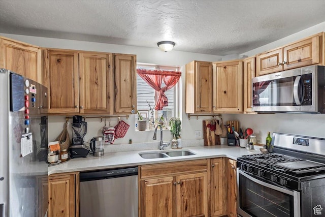 2669 S Liberty Ave E, Ogden, UT 84401 - kitchen with a textured ceiling, stainless steel appliances, light countertops, and a sink
