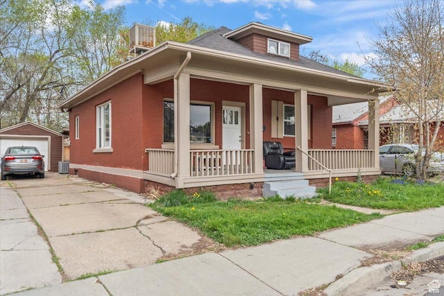 2669 S Liberty Ave E, Ogden, UT 84401 - view of front facade with central AC unit, driveway, a porch, an outbuilding, and a garage