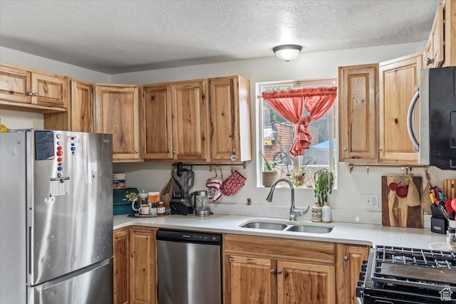 2669 S Liberty Ave E, Ogden, UT 84401 - kitchen with light countertops, a sink, a textured ceiling, and appliances with stainless steel finishes