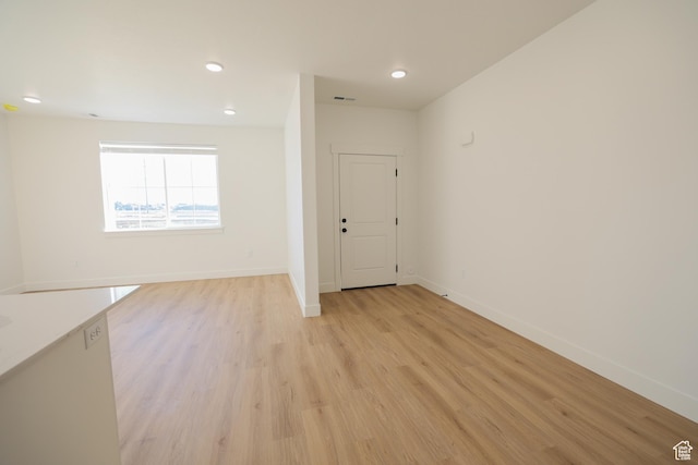 unfurnished room featuring visible vents, light wood-style flooring, baseboards, and recessed lighting