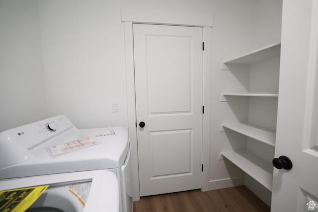 laundry room with dark wood finished floors, washer and clothes dryer, and laundry area