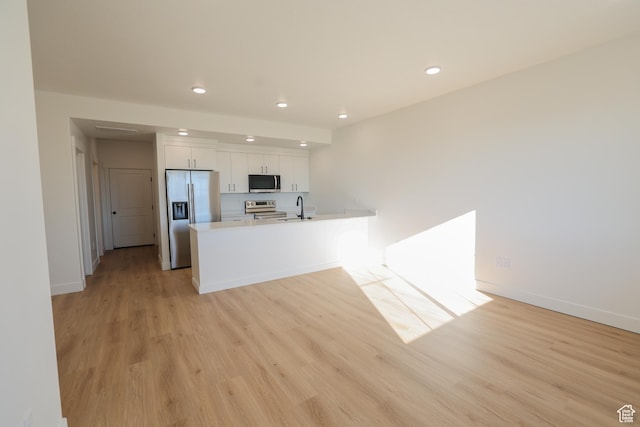 kitchen with recessed lighting, white cabinets, stainless steel appliances, and a sink