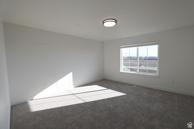 carpeted empty room with visible vents and baseboards
