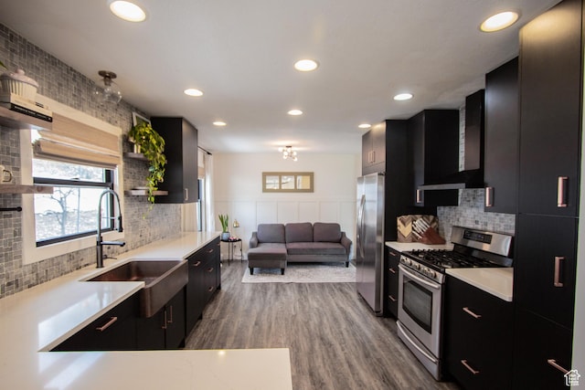 64 Winding Way, Logan, UT 84321 - kitchen featuring wall chimney range hood, dark cabinets, open shelves, and stainless steel appliances