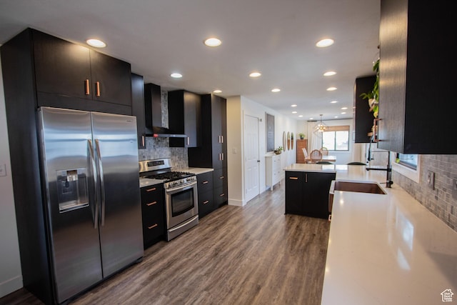 64 Winding Way, Logan, UT 84321 - kitchen with wall chimney exhaust hood, stainless steel appliances, dark wood finished floors, backsplash, and light countertops