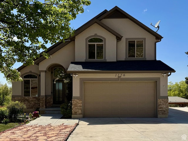 1126 E Bench View Dr N, Ogden, UT 84404 - view of front facade with stucco siding, an attached garage, driveway, and stone siding