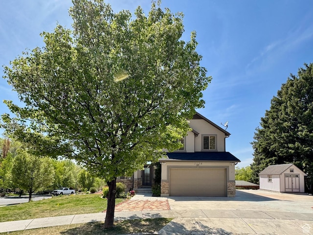 1126 E Bench View Dr N, Ogden, UT 84404 - obstructed view of property with a shed, concrete driveway, stone siding, a garage, and stucco siding