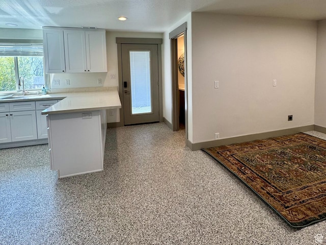 1126 E Bench View Dr N, Ogden, UT 84404 - kitchen with a sink, light countertops, baseboards, white cabinets, and a peninsula
