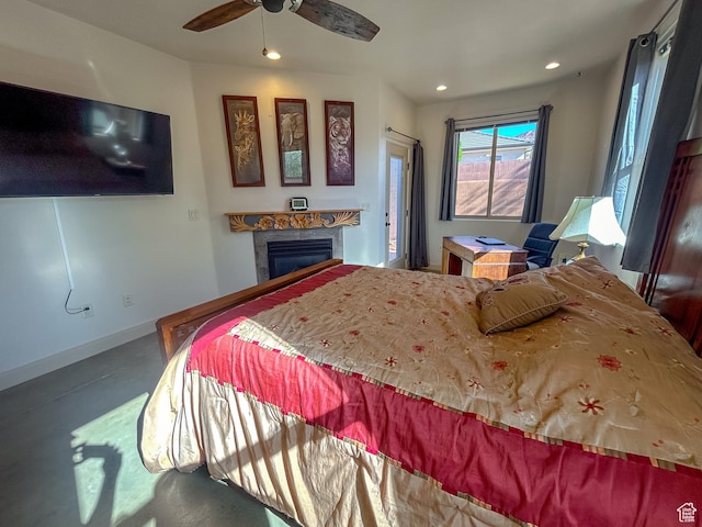 bedroom featuring recessed lighting, baseboards, finished concrete floors, a glass covered fireplace, and ceiling fan
