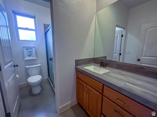 bathroom with a stall shower, baseboards, vanity, and toilet