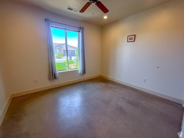 unfurnished room featuring concrete floors, a ceiling fan, visible vents, and baseboards