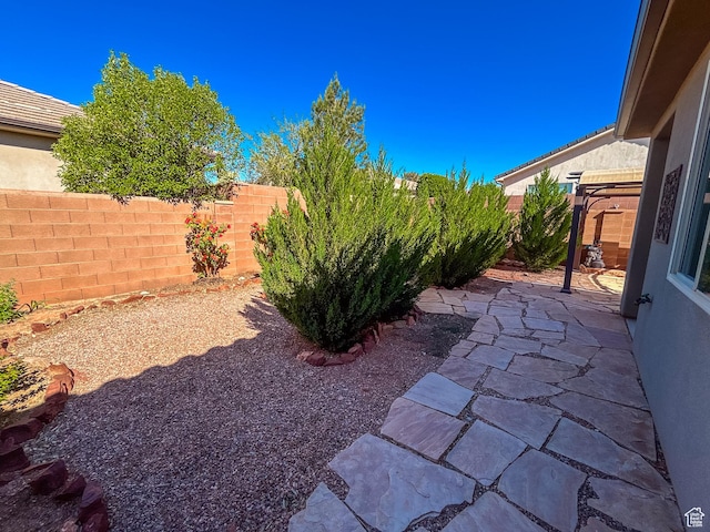 view of yard featuring fence and a patio