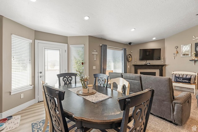 1317 N Providence Way, Tooele, UT 84074 - dining area with recessed lighting, baseboards, a fireplace, light wood-style flooring, and a textured ceiling