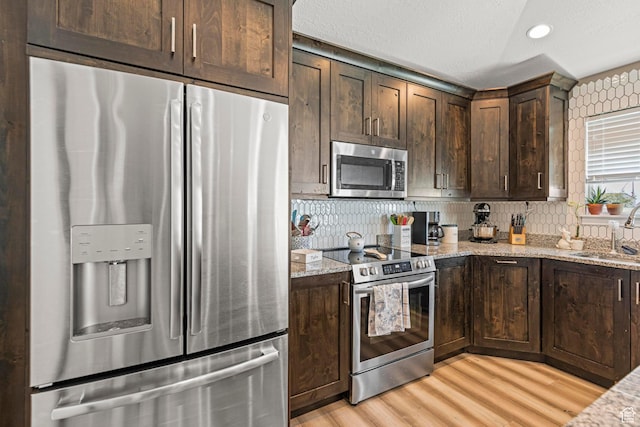 1317 N Providence Way, Tooele, UT 84074 - kitchen featuring dark brown cabinetry, stainless steel appliances, a sink, and light wood finished floors