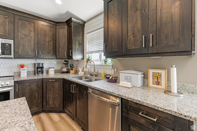 1317 N Providence Way, Tooele, UT 84074 - kitchen with dark brown cabinetry, light stone counters, a sink, and appliances with stainless steel finishes