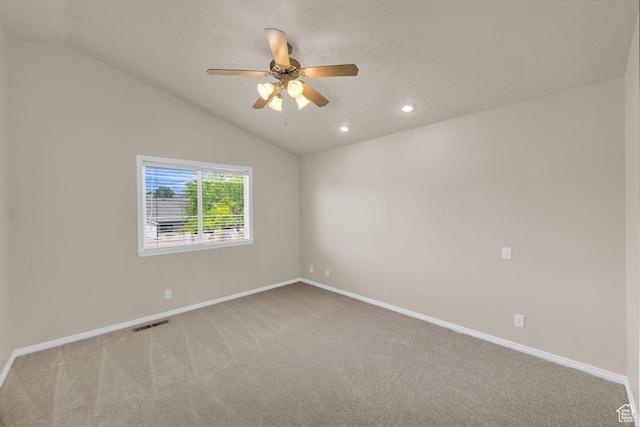 carpeted empty room featuring vaulted ceiling, visible vents, baseboards, recessed lighting, and ceiling fan