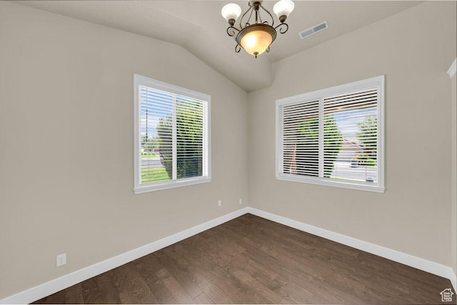 empty room with vaulted ceiling, baseboards, visible vents, an inviting chandelier, and dark wood-type flooring