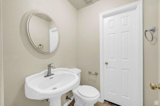 half bathroom with visible vents, toilet, and a sink