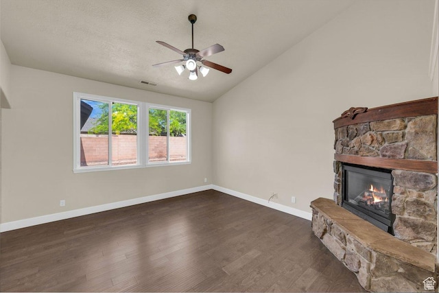 unfurnished living room with dark wood finished floors, visible vents, lofted ceiling, ceiling fan, and a fireplace
