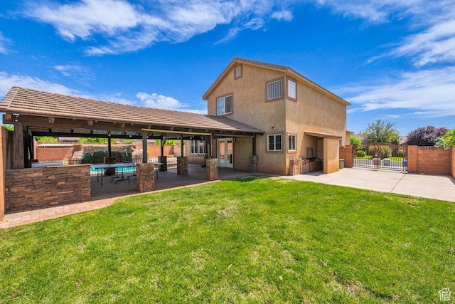 rear view of house featuring fence, a lawn, and a patio area