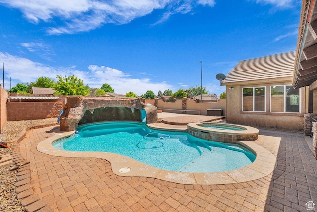 view of swimming pool with a fenced backyard, a patio area, and a pool with connected hot tub