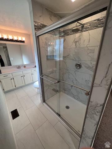 bathroom with vanity, marble finish floor, and a stall shower