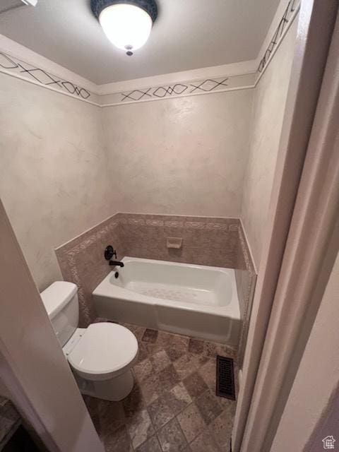 bathroom featuring a bath, visible vents, and toilet