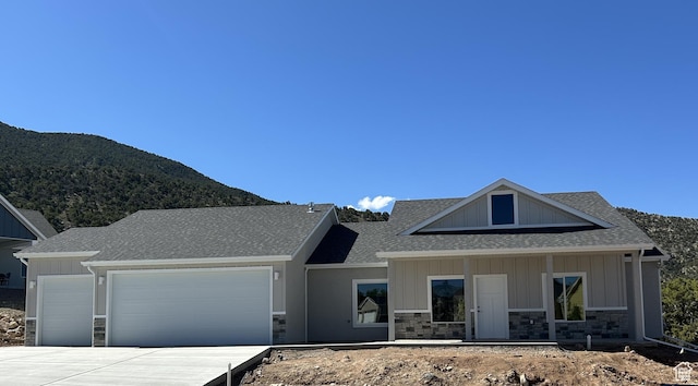 1152 E Smokey Trail Way, Cedar City, UT 84721 - view of front of home featuring an attached garage, a mountain view, roof with shingles, concrete driveway, and board and batten siding
