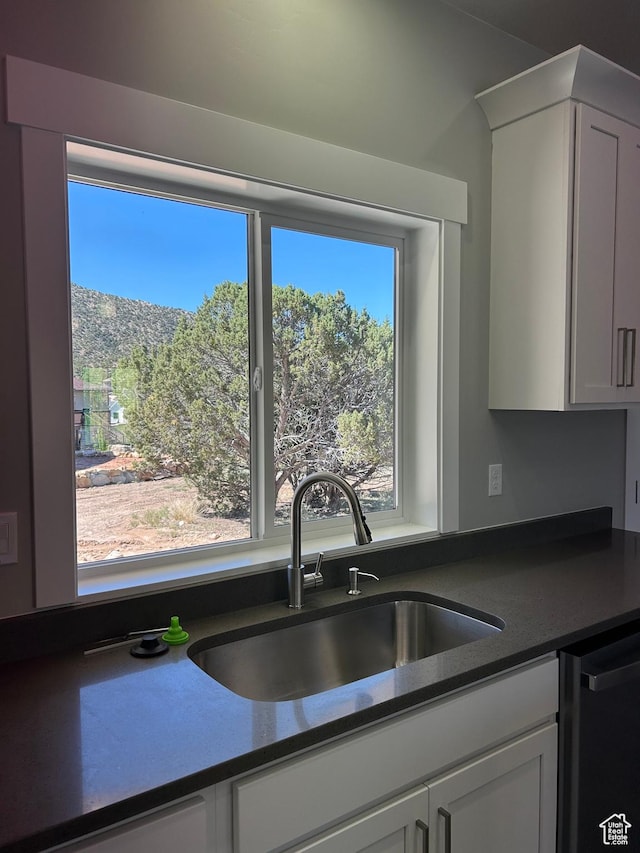 1152 E Smokey Trail Way, Cedar City, UT 84721 - kitchen with dishwasher, a sink, dark countertops, and white cabinetry