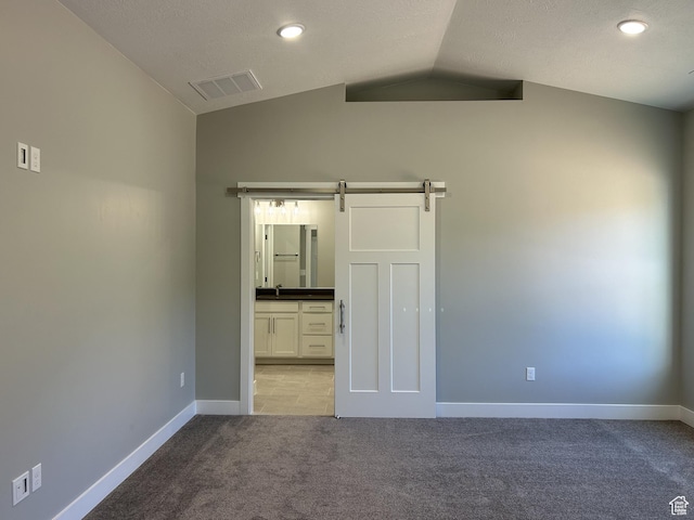 1152 E Smokey Trail Way, Cedar City, UT 84721 - unfurnished bedroom with light colored carpet, a barn door, vaulted ceiling, baseboards, and a sink