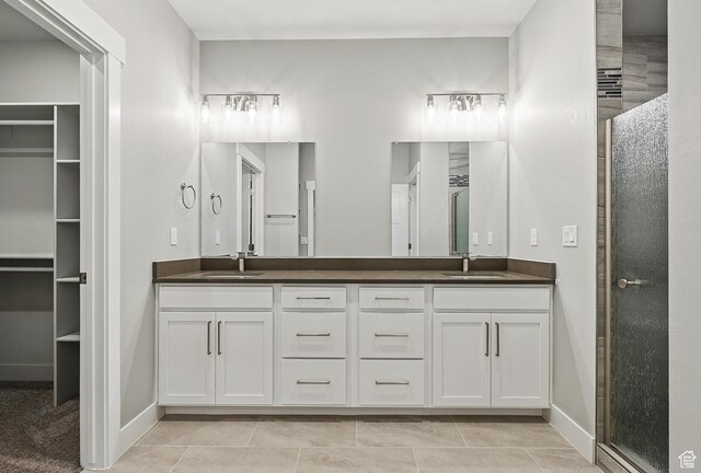 1152 E Smokey Trail Way, Cedar City, UT 84721 - bathroom featuring double vanity, a shower with shower door, baseboards, and a walk in closet
