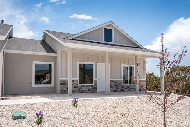 1152 E Smokey Trail Way, Cedar City, UT 84721 - rear view of house featuring roof with shingles, board and batten siding, covered porch, and stone siding