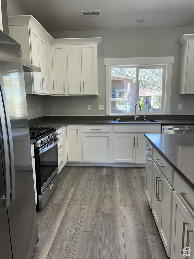 1152 E Smokey Trail Way, Cedar City, UT 84721 - kitchen with stainless steel appliances, a sink, dark wood-style flooring, and white cabinetry