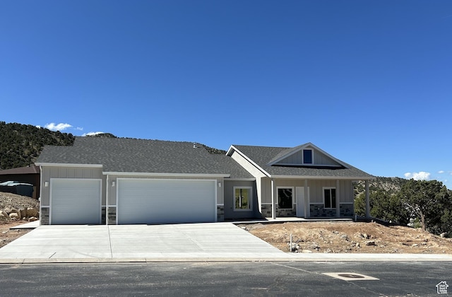 1152 E Smokey Trail Way, Cedar City, UT 84721 - view of front facade featuring stone siding, board and batten siding, an attached garage, and driveway