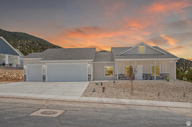 1152 E Smokey Trail Way, Cedar City, UT 84721 - view of front of home featuring stone siding, a garage, concrete driveway, and board and batten siding